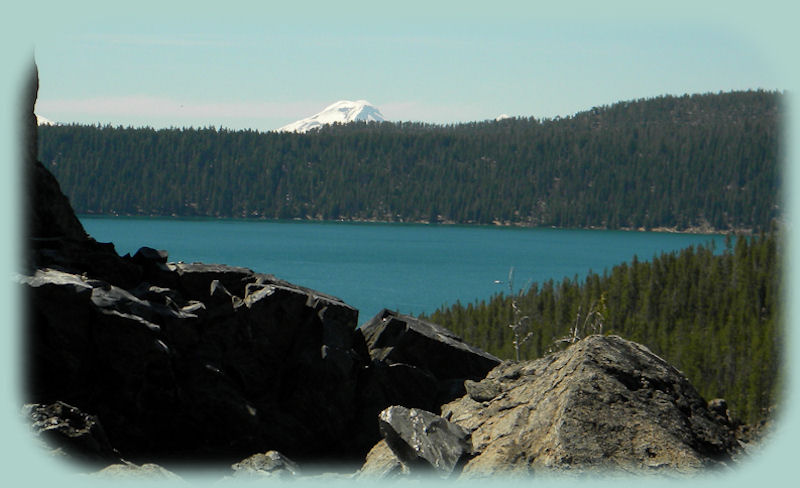 Paulina Lake viewed from the big obsidian flow at newberry national volcanic monument in oregon, under the auspices of the deschutes national forest of oregon, and it includes benham falls on the wild and scenic deschutes river, lava cast forest, lava river cave, lava lands, paulina and east lakes, paulina creek falls, paulina peak, campgrounds, hiking trails, hot springs and more.