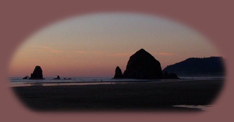 haystack rock in the pacific ocean at sunset at cannon beach on the oregon coast.